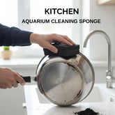 Person cleaning a rusty pot with a kitchen aquarium cleaning sponge