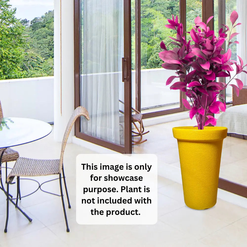 Yellow planter with pink plant on a balcony with greenery outside