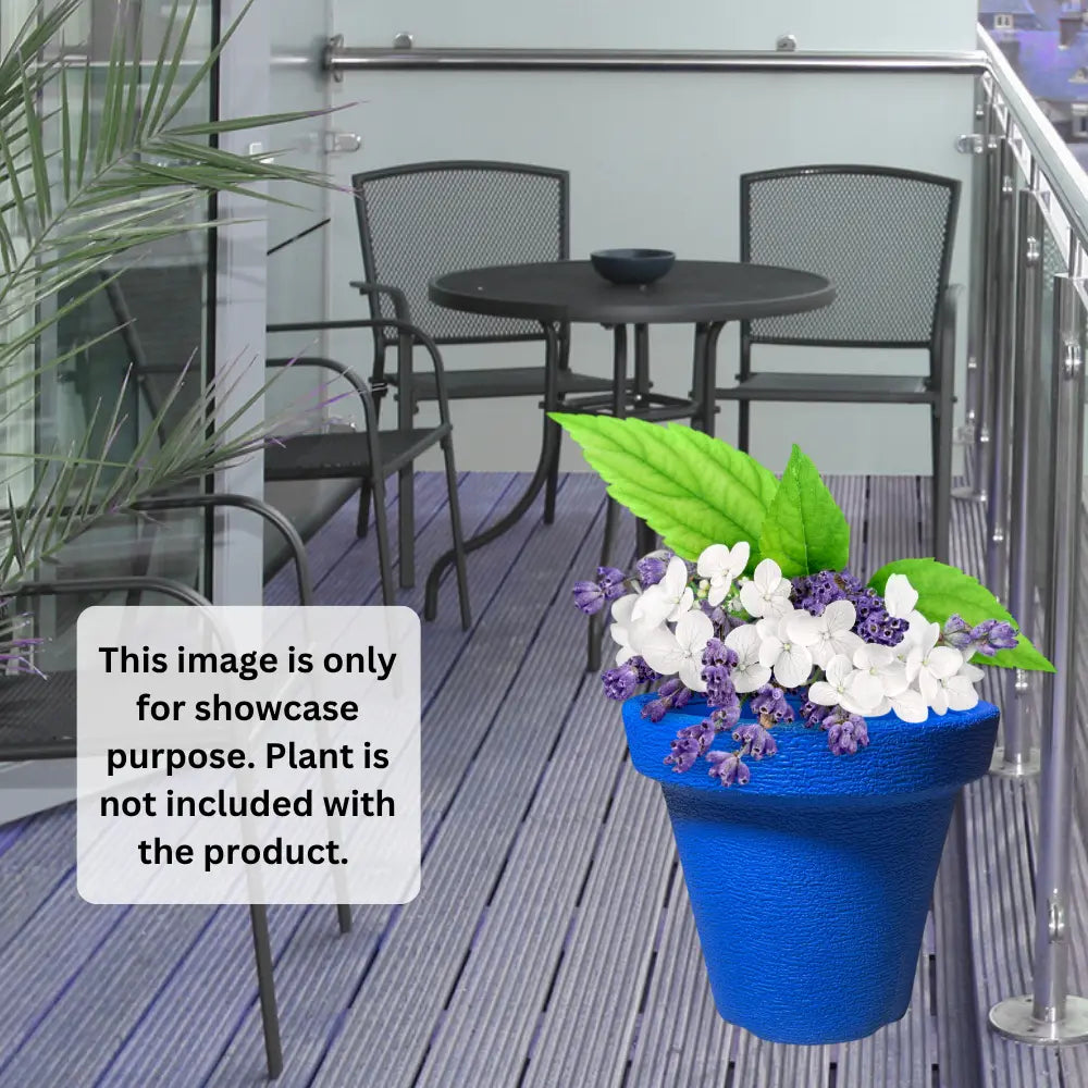Blue planter with flowers on a patio with chairs and a table.