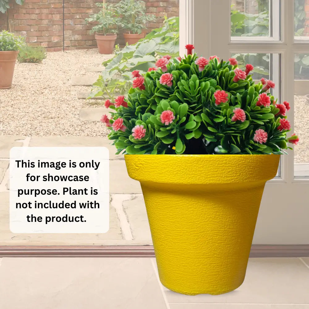 Yellow planter with pink flowers on a patio