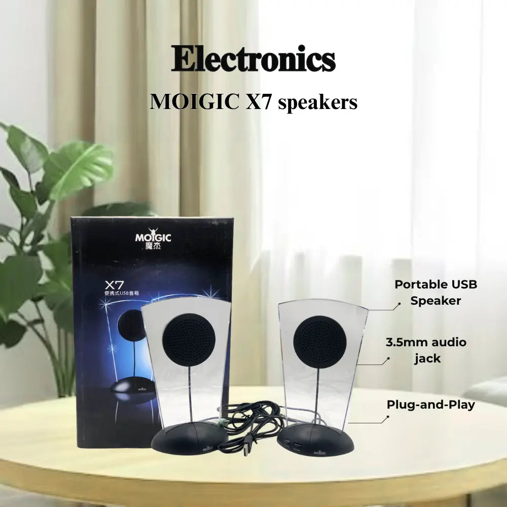 MOIGIC X7 speakers with packaging on a table, indoor setting